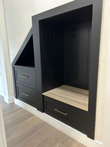 Modern black built-in bench and drawer unit crafted by CFL Custom Carpentry, highlighting elegant and functional space-saving carpentry that maximizes under-stair storage with a sleek, custom design.