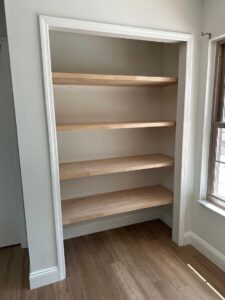 Custom built-in wood shelving by CFL Custom Carpentry, offering functional storage that aligns with seasonal home maintenance tips for organizing indoor spaces.