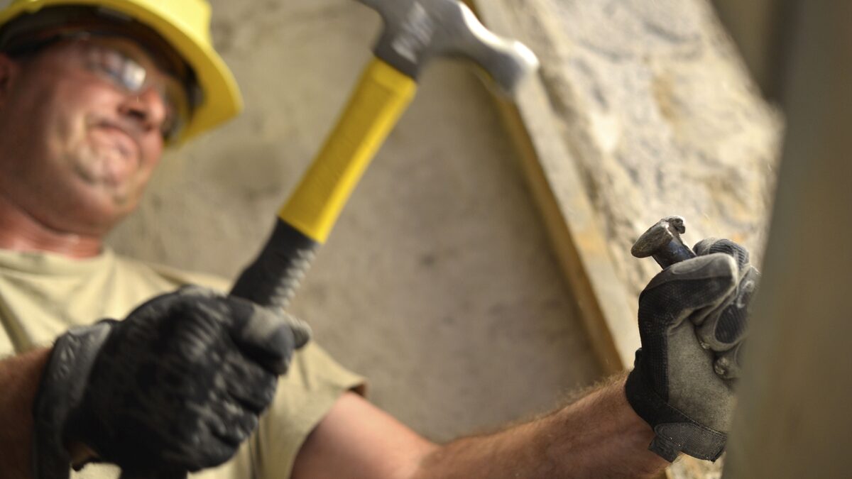 Carpenter wearing safety goggles and gloves