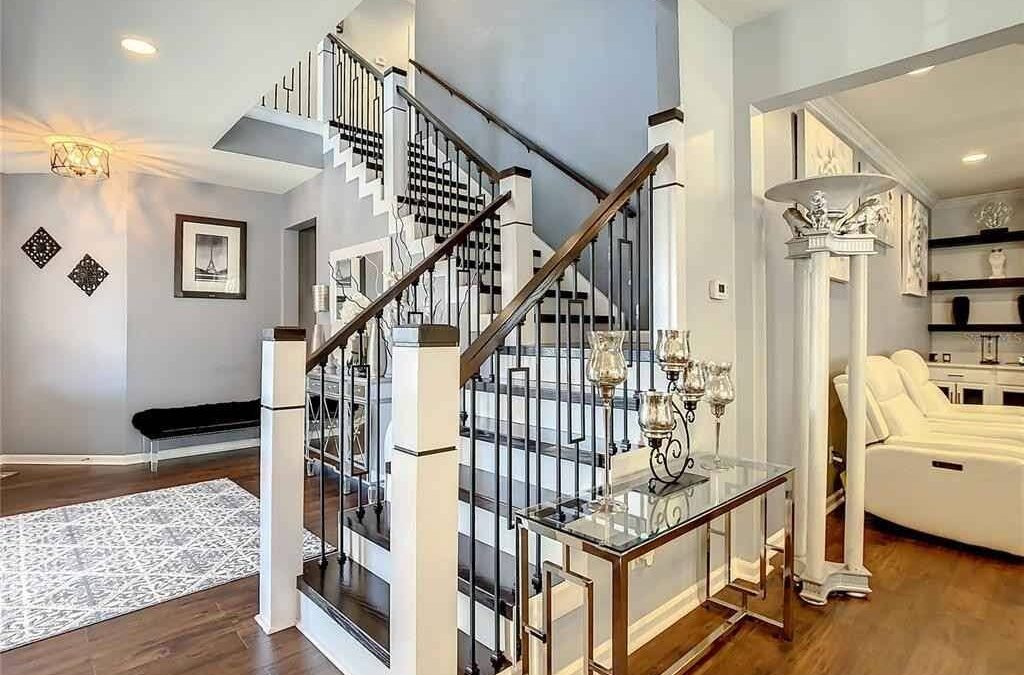 Modern staircase design tips by CFL Custom Carpentry showcasing elegant wood and iron railing combination in a contemporary home.